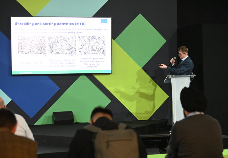 A man presenting a slide in front of a seated audience.