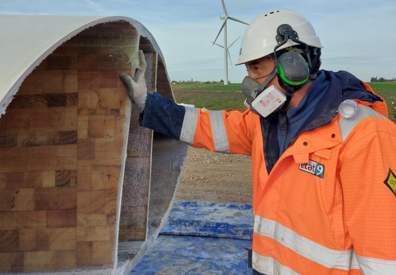 Man in PPE looking into turbine blade.
