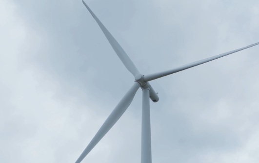 Wind turbine rotor blades against grey sky