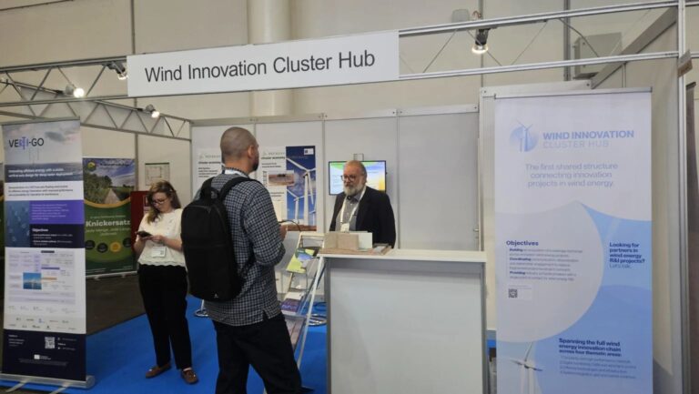 A person on an exhibition stand under the banner Wind Innovation Cluster Hub.